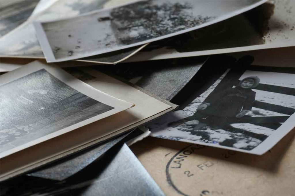 Old family photos representing ancestry, hidden family trauma, and healing generational patterns with Family Constellation therapy.