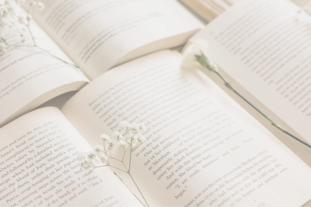 Open book with delicate white flowers symbolizing reflection and the final page of a story