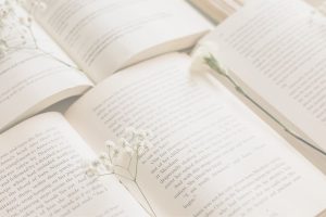 Open book with delicate white flowers symbolizing reflection and the final page of a story