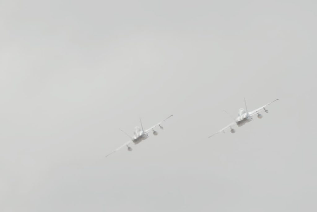 Two fighter jets flying together into a hazy sky, symbolizing survivor's guilt and the bond between those who make it through and those who don't
