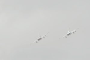 Two fighter jets flying together into a hazy sky, symbolizing survivor's guilt and the bond between those who make it through and those who don't