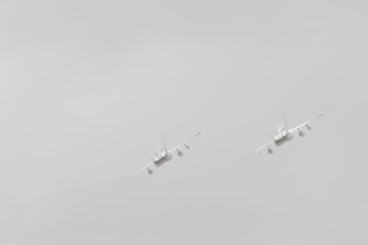 Two fighter jets flying together into a hazy sky, symbolizing survivor's guilt and the bond between those who make it through and those who don't